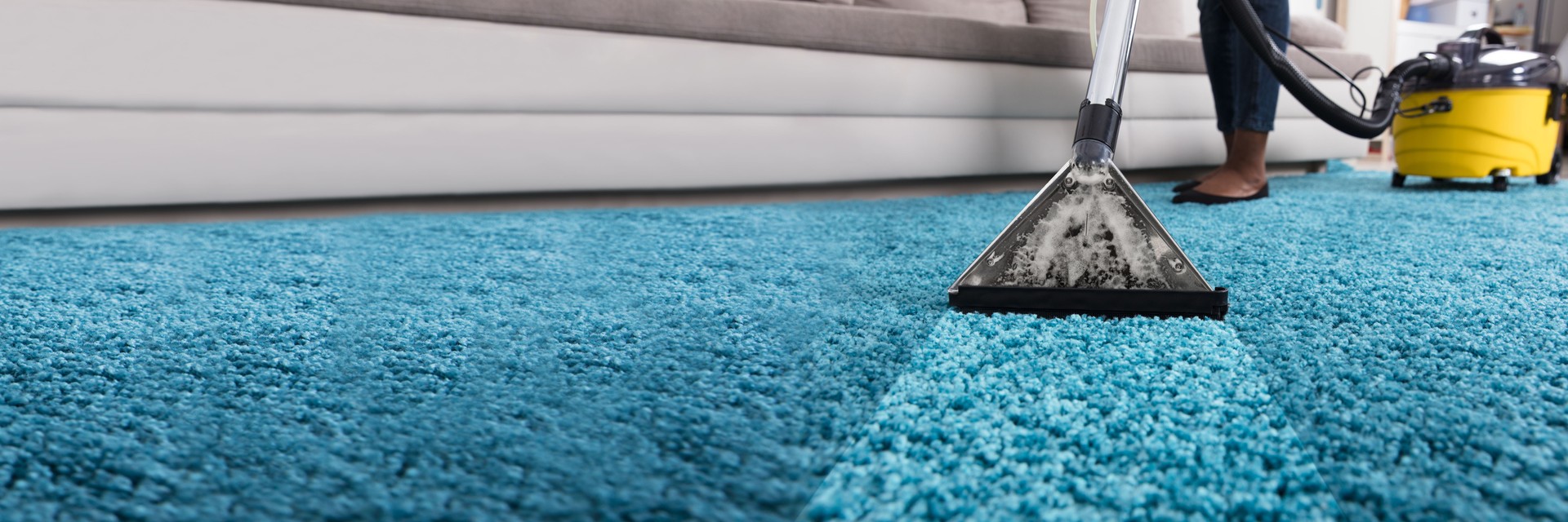 Person Using Vacuum Cleaner For Cleaning Carpet
